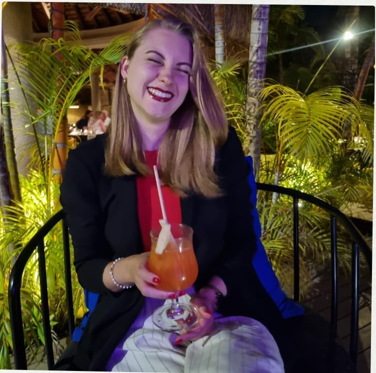 Michelle lacht mit einem Cocktail in der Hand